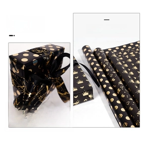 Detail showing black and gold foil gift wrapping paper with heart and crown patterns