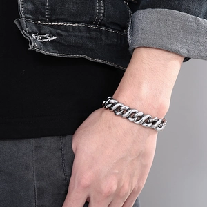 Close-up of hip-hop men's stainless steel Cuban chain bracelet on wrist with aged silver finish