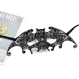 Macro detail of black lace bat mask showing intricate cutout patterns and ribbon ties