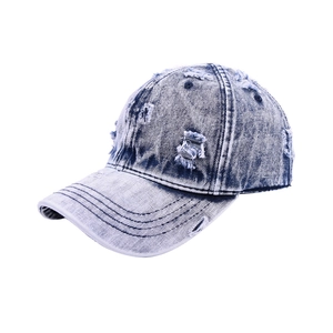 Detailed macro shot of distressed ripped texture on vintage washed denim baseball cap