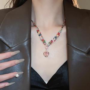 Detailed close-up of zircon heart pendant necklace with colorful crystals on model neck