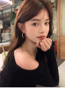 Silver irregular large circle earrings worn by a model in a cozy cafe setting