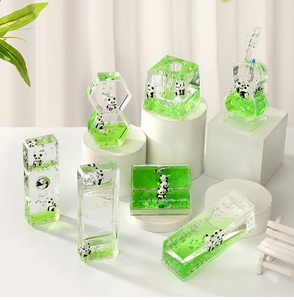 Macro detail of various geometric acrylic panda liquid desk ornaments with green floating oil