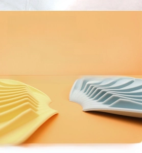 Detail of silicone soap dish with drainage grooves and non-slip surface in yellow and blue