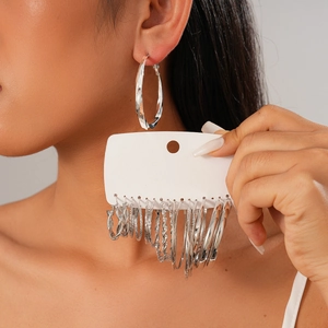 Detail shot of a 16-piece set of silver geometric hoop earrings in various sizes and textures