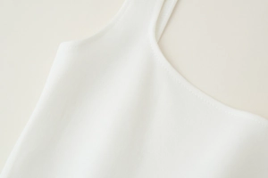 Gros plan sur la texture du tricot blanc et les coutures propres de l'encolure dos nu