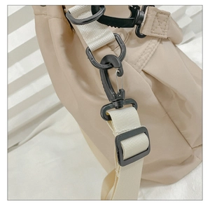 Detail of nylon bucket bag featuring a black swivel hook and durable beige webbing