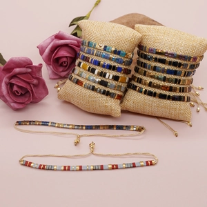 Colorful Tila bead handmade woven bracelets set on linen display pillows for unisex wear