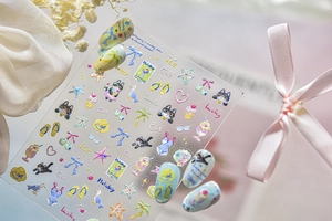 Macro detail of summer cat 3D embossed nail stickers on light blue faux nails