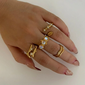 Retro gold stackable ring set with moonstones and geometric twig designs on hand