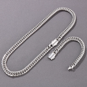 Close-up of polished silver Cuban link necklace and bracelet set with secure clasps