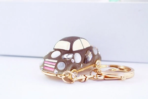 Macro shot of brown rhinestone car keychain with sparkling crystals and golden clasp