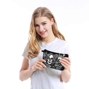 Waterproof black makeup bag with skull and rose print held by a model on white background