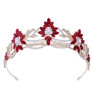 Detailed view of floral bridal crown with red marquise gems and gold leaf setting