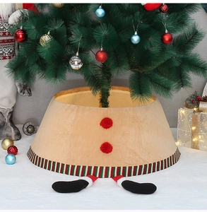 Detail of khaki fabric Christmas tree skirt with elf legs and red pom-poms decor