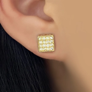 Macro shot of gold square stud earrings with full zircon inlay worn by a model