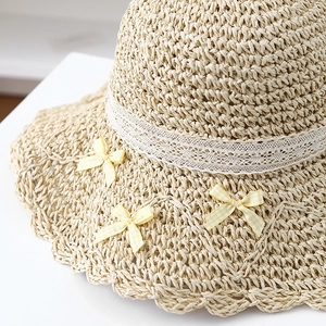 Women's summer straw sun hat with white lace trim and yellow checkered bows