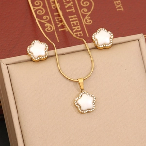 Golden flower jewelry set with white petals and crystals on a snake chain necklace