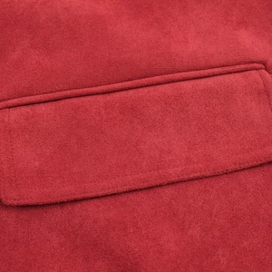 Detailed macro view of the pocket stitching and soft suede texture on a red jacket