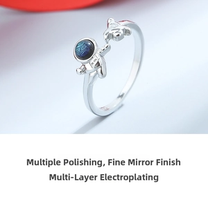 Macro shot of silver astronaut ring with blue starry glass stone and rocket detail