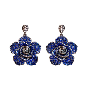 Vintage silver flower stud earrings with blue and clear zircons on white background