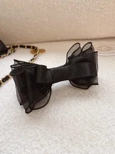 Close-up of black double-layered mesh bow banana clip with elegant silk texture