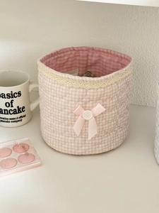Close-up of pink checkered quilted fabric storage bin with lace trim and ribbon bow