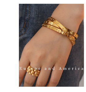Detail of 18K gold plated bangle with star engraving and matching chain ring set