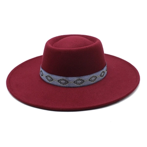 Detail of burgundy wool fedora hat featuring a vintage geometric woven band on flat top