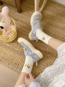 Close-up of white socks featuring cute dog patterns and text detail in casual sandals
