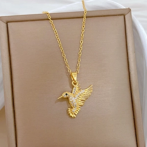 Detailed view of hummingbird pendant with sparkling white crystals on a luxury jewelry box
