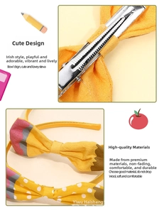 Detail of yellow polka dot fabric bow with pencil motif and metal alligator clip