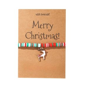 Detailed view of a Christmas wish bracelet with reindeer charm on a kraft card
