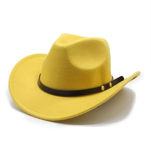 Close-up of a yellow felt cowboy hat featuring a brown leather band and gold buckles