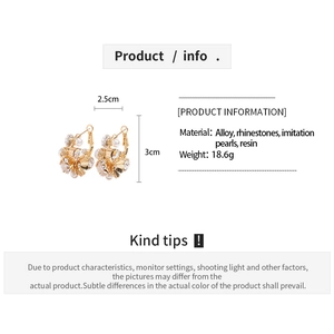 Detailed spec view of flower earrings with rhinestones, pearls and size 2.5cm by 3cm