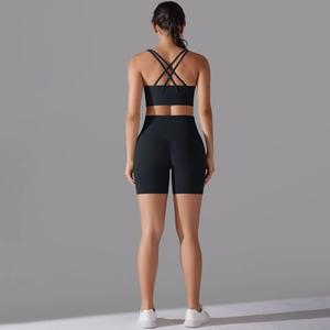 Dettaglio delle spalline incrociate sul retro di un set fitness nero a vita alta
