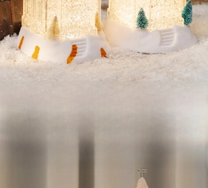 Close-up of a Christmas house lantern with warm LED lights and sparkling snow glitter