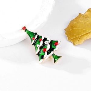 Detail of Christmas tree brooch with green enamel, red rhinestones and gold alloy base