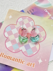 Macro detail of pink and green resin tulip earrings on a romantic floral card