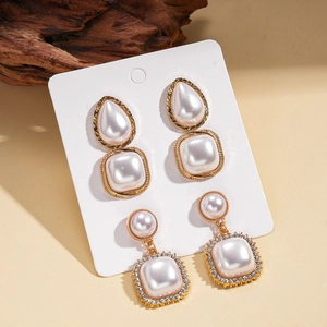 Detailed macro view of vintage baroque gold earrings with drop and square pearls