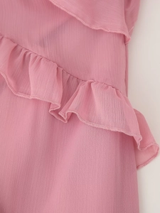 Detailansicht eines rosa Chiffonkleids mit Volants und feinem, gerolltem Saum-Design