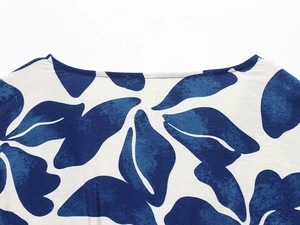 Detail des V-Ausschnitts mit blau-weißem Pflanzendruck auf ärmellosem Sommerkleid