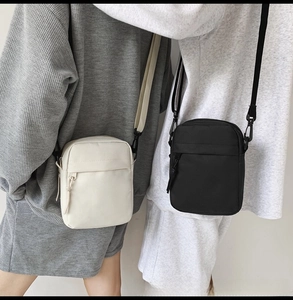 Dual model display of minimalist nylon crossbody bags in black and white colors