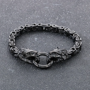 Dettaglio del bracciale a catena bizantina nera con doppie teste di leone su fondo scuro