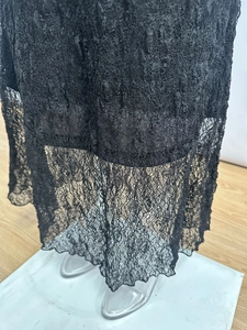 Détail de l'ourlet de la jupe en dentelle noire semi-transparente à motifs floraux