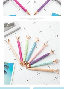 Detail of colorful glitter ballpoint pens with large crystals on a minimalist background