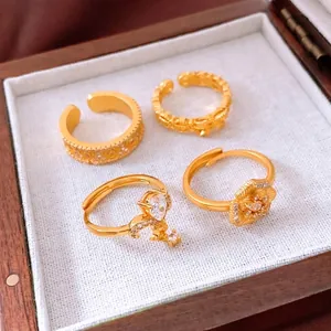 Set of four vintage 24K gold plated rings with floral and zircon designs in a luxury box