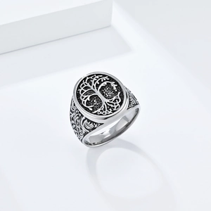 Detailed view of silver tree of life ring with intricate floral engraving on side