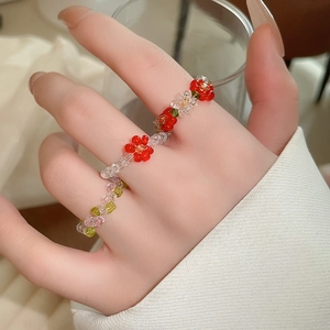 Close-up of handmade beaded flower ring with colorful acrylic glass beads worn by a model