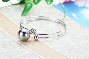 Macro shot of silver double-band cuff bracelet featuring mirror-polished metal spheres
